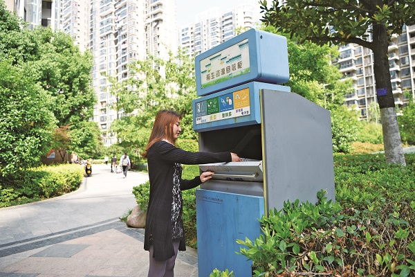 左1=配图：在振徽苑，居民向再生资源回收柜里投放报纸 谢文君 崔晓林 摄.jpg